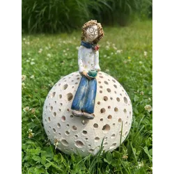 Ceramiczna figurka kobiety siedzącej na ażurowej kuli